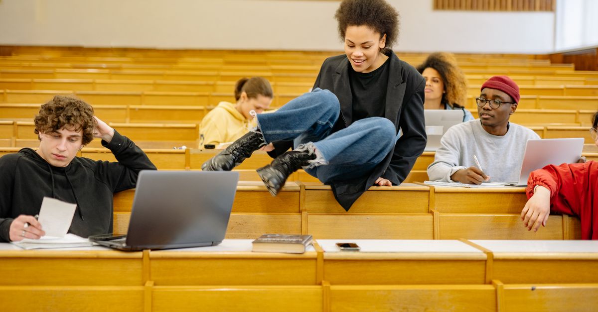 Diverse students interact and study in a university lecture hall.